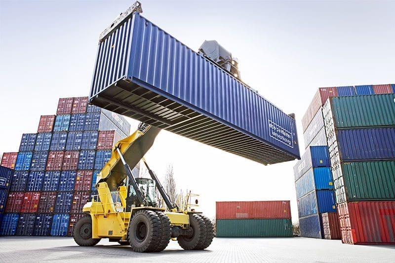 Container werden von einem Bagger gestapelt